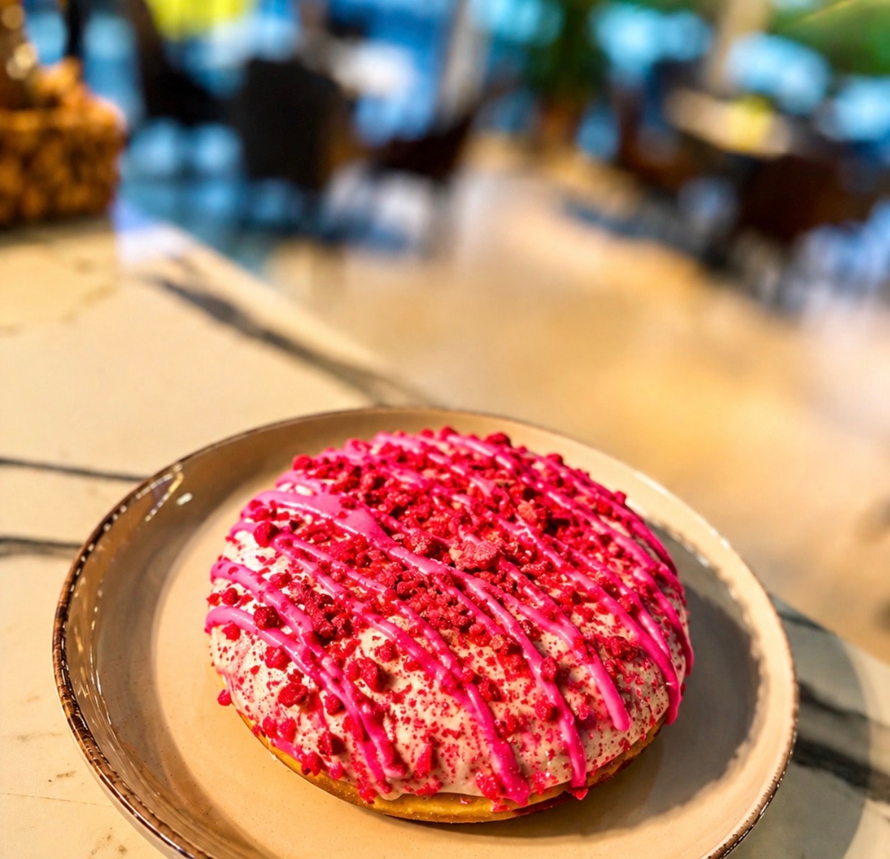 Raspberry glazed donut on a ceramic plate